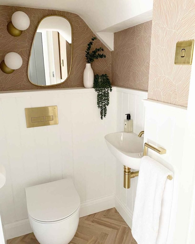 Small decorative details can completely change the look of a compact toilet room. Adding warm gold accents, like faucets, towel rails, mirror frames, or cabinet hardware, creates a refined and luxurious feel without making the space appear crowded.