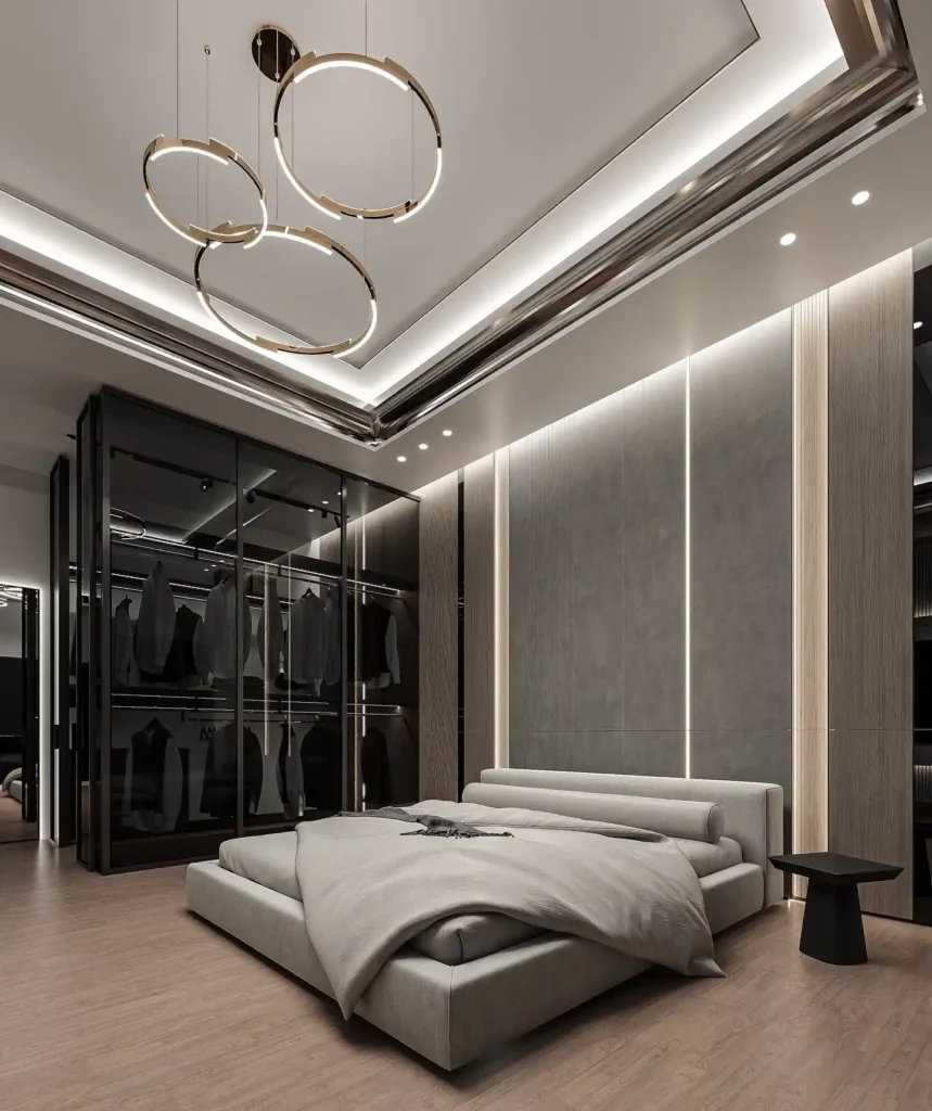 Gold ring chandelier, grey platform bed and glass-door clothes closet in a modern bedroom
