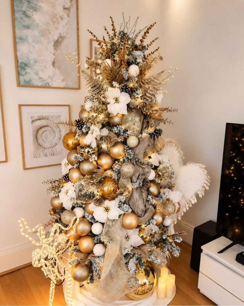 Champagne gold and white Christmas tree decorated with metallic baubles, white poinsettias, gold mesh ribbon, frosted branches, and warm lights.